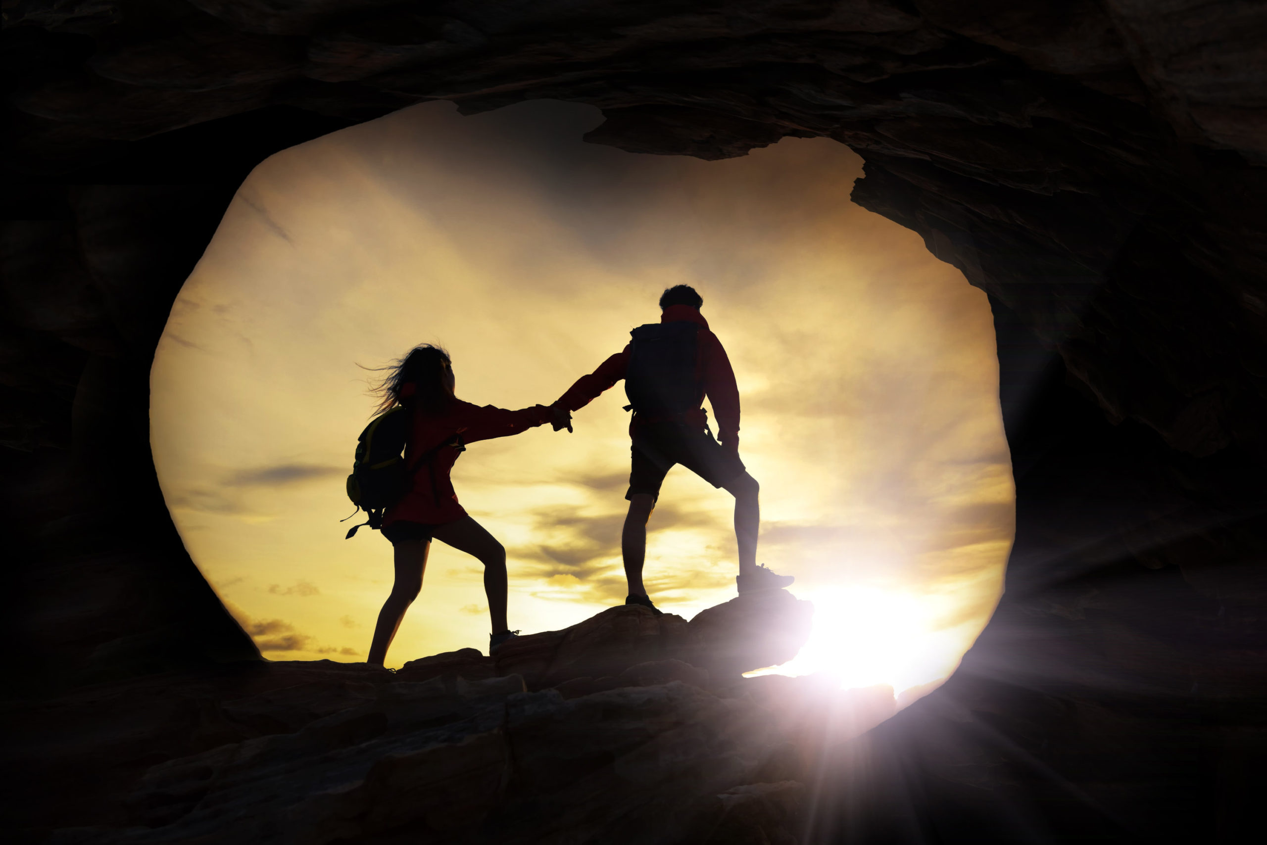 Couple emerging from dark cave