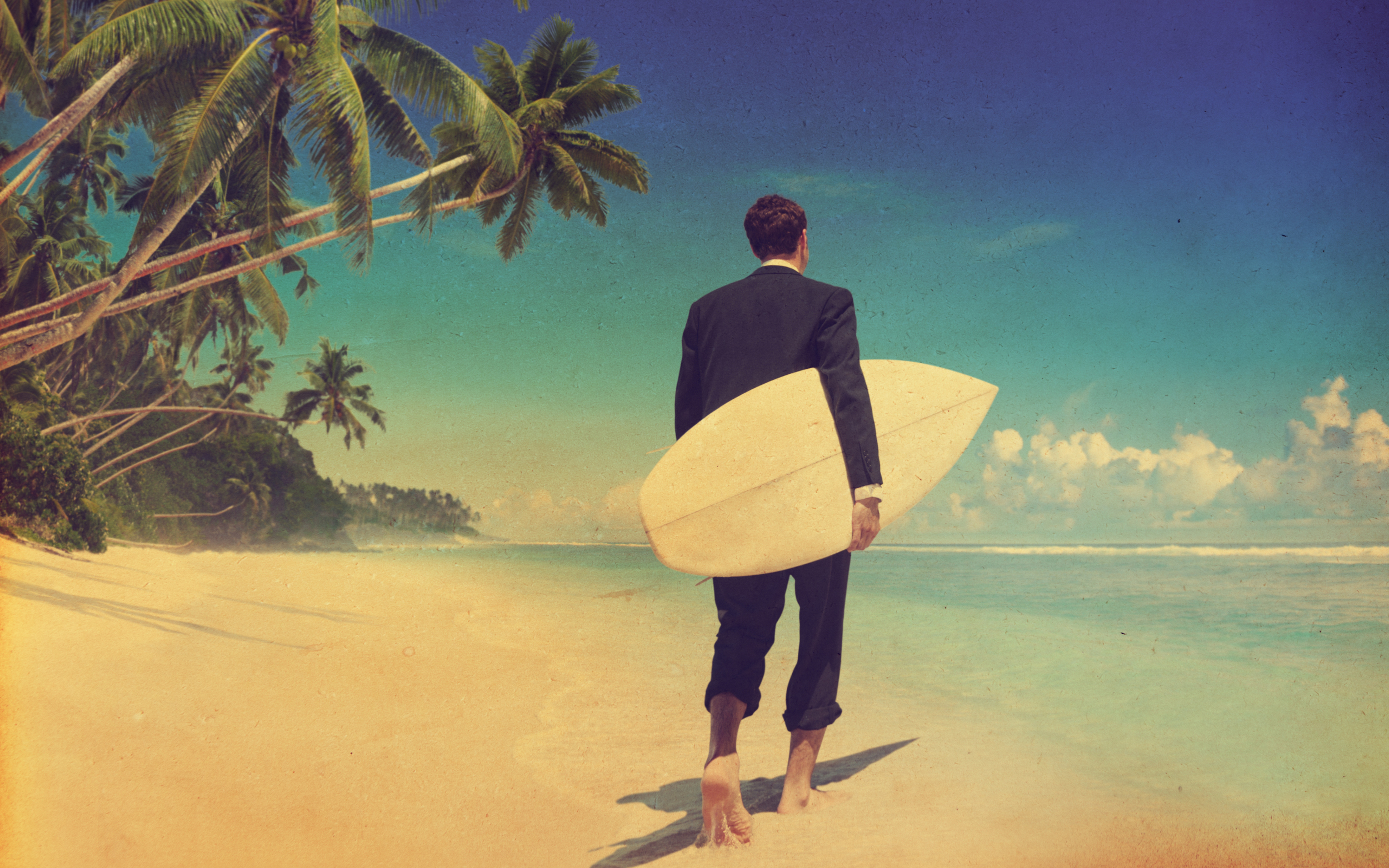 Barefoot man in Business suit carrying surfboard