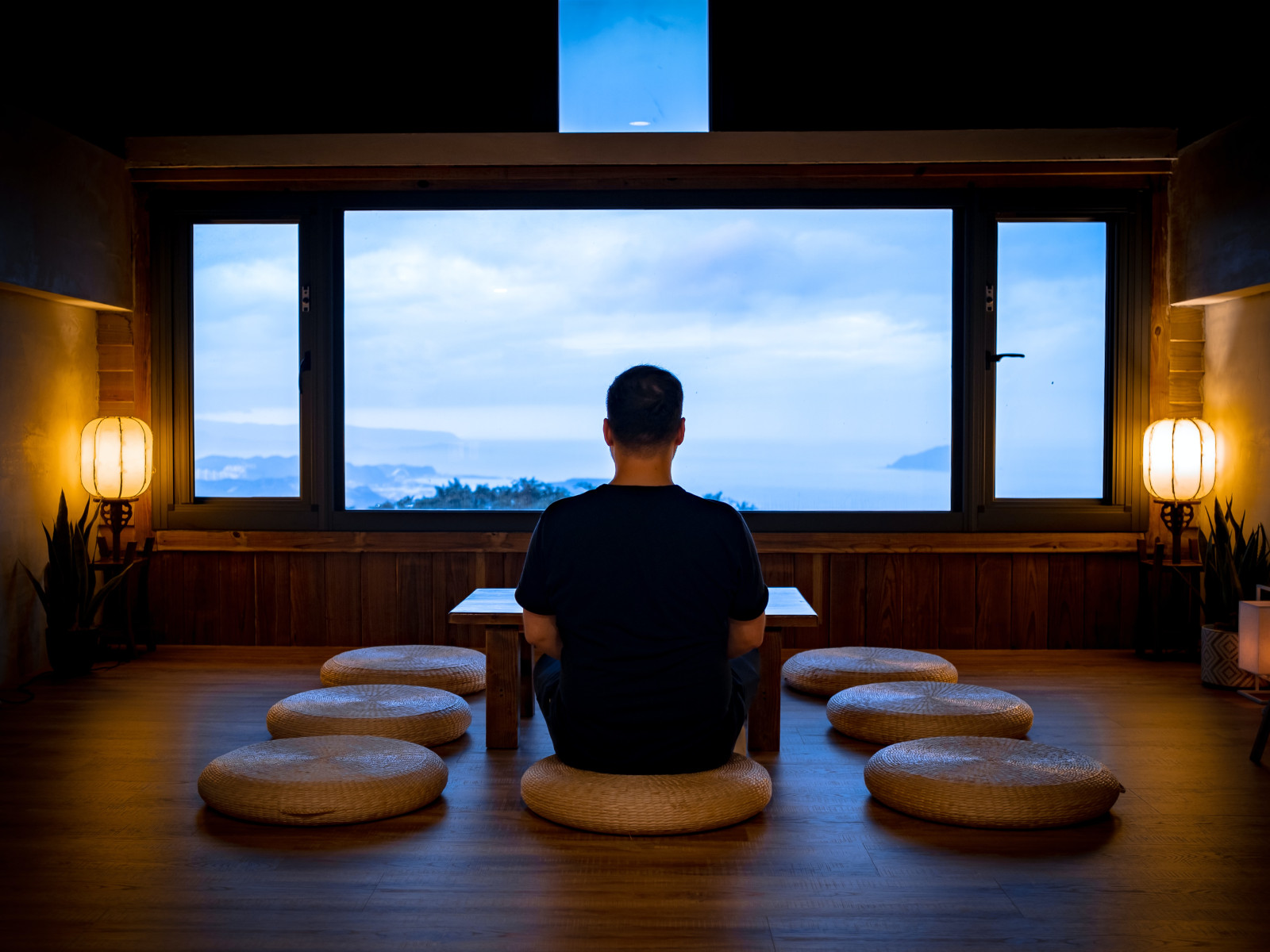 Spiritual man sitting in front of picture window with beautiful vista